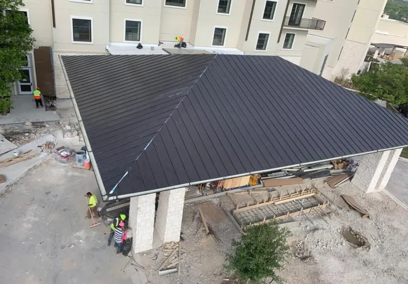Metal roofing installation team working on a commercial building in Pinecrest